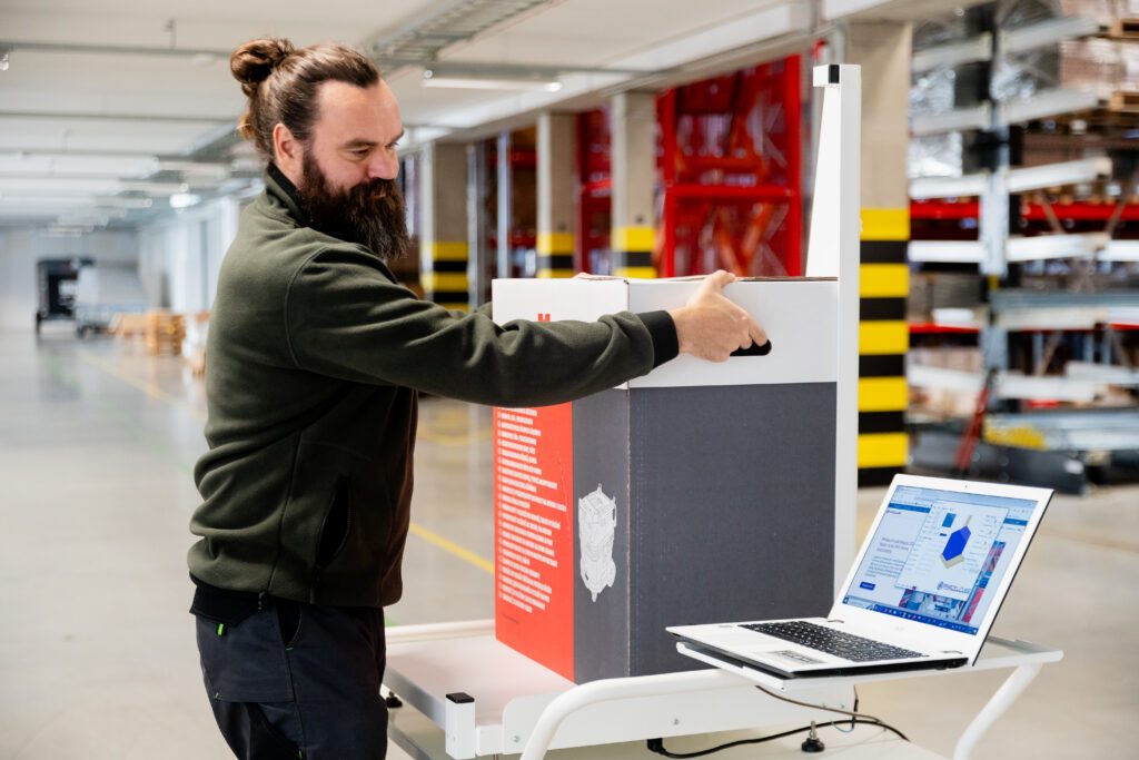 Parcelcube 900 in use at Würth warehouse, measuring packages, shelves of inventory in the background