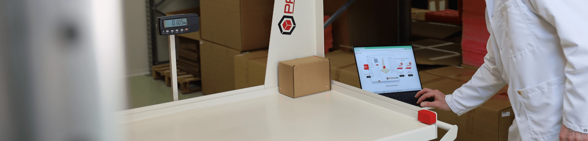 An e-commerce worker using the Parcelcube 1000 device to measure the size and weight of a parcel, with the data automatically transferred to a computer.