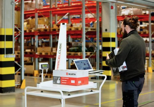 Parcelcube 900 in use at Würth warehouse, measuring packages, shelves of inventory in the background