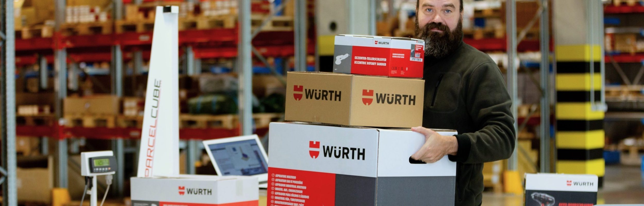 Parcelcube 900 in use at Würth warehouse, measuring packages, shelves of inventory in the background